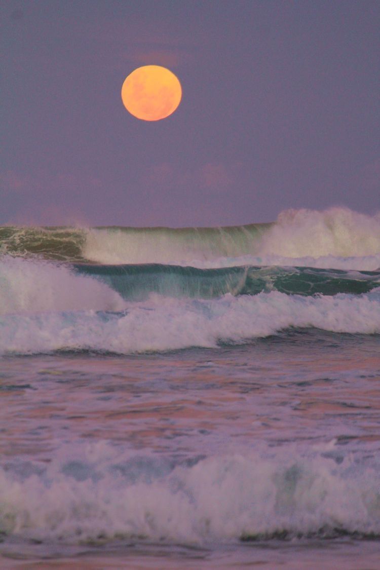 Full moon rising over ocean waves